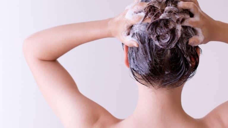 Mulher massageando o próprio couro cabeludo