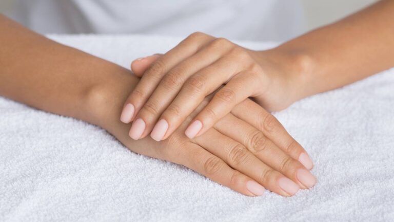 Mulher com unhas em tons nude