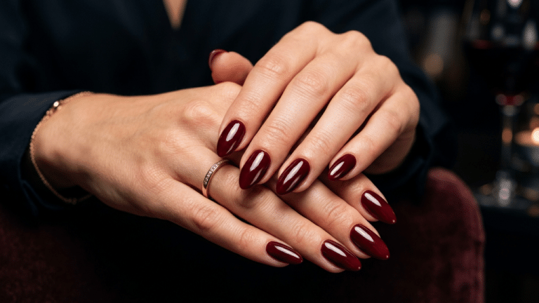 mãos femininas com unhas pintadas em tom vinho profundo