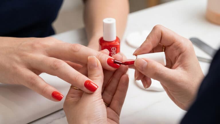 Unhas sendo pintadas de vermelho