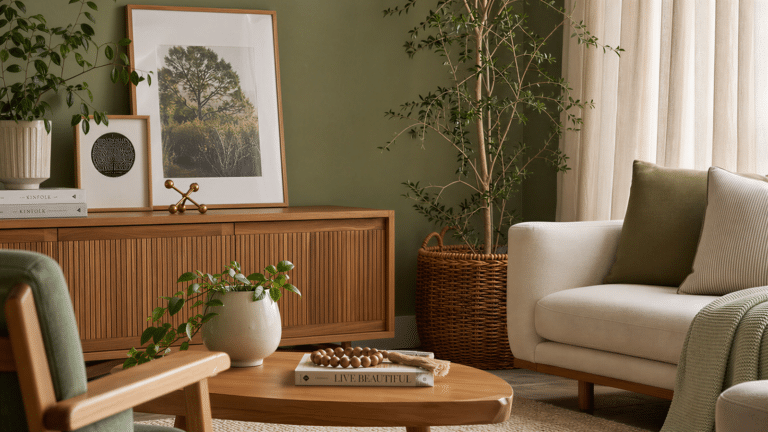Sala com parede verde sálvi e móveis de madeira