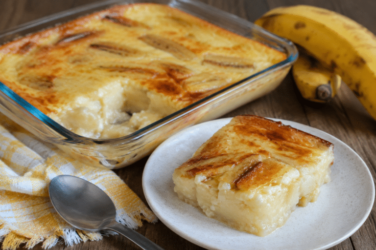 Fatia de banana cremosa na Air Fryer servida em prato branco, com textura macia e cremosa sobre mesa de madeira.