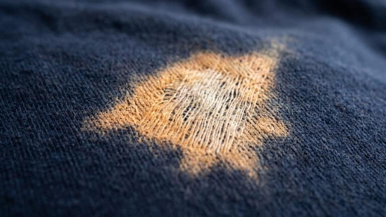 Calça azul com mancha de água sanitária