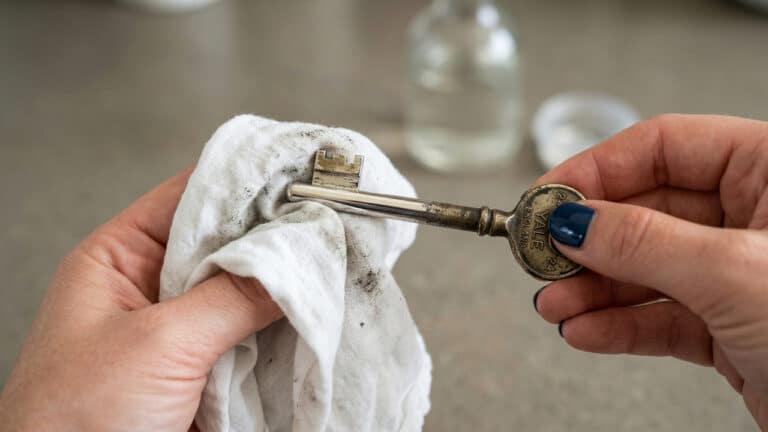 Chave sendo seca com pano após limpeza com vinagre