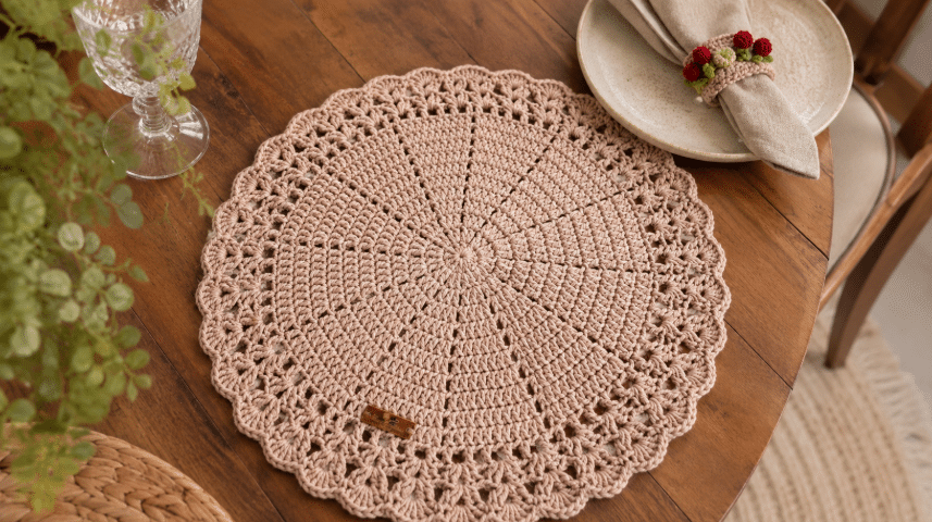 Os gráficos de sousplat de crochê em tom neutro traz elegância artesanal para uma mesa posta delicada