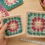 Squares de crochê com tamanhos diferentes sendo comparados antes da união