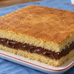 Bolo retangular de massa amanteigada com duas camadas e recheio cremoso de chocolate ao leite.