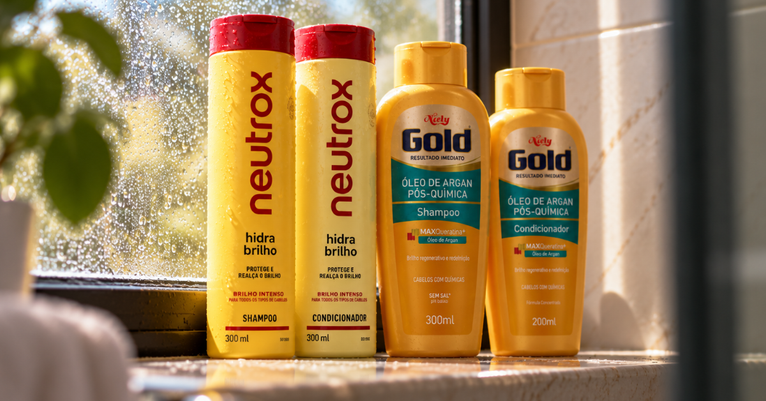Shampoos e condicionadores Neutrox Hidra Brilho e Niely Gold Pós-Química sobre uma bancada iluminada pelo sol.
