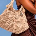 Bolsa de crochê bege com desenhos geométricos mostra como o trabalho artesanal pode ganhar um acabamento sofisticado e elegante. © Studio Katia Ribeiro